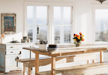 Large rustic wooden dining table and bench in white rustic room