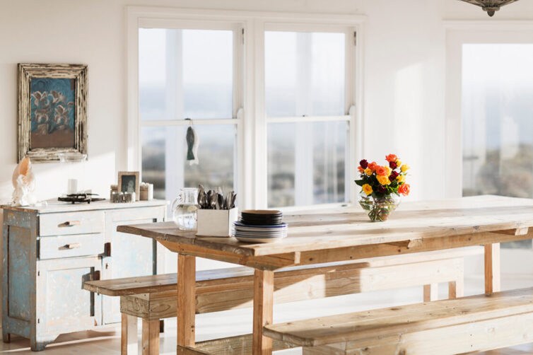 Large rustic wooden dining table and bench in white rustic room