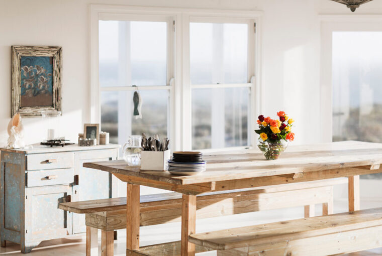 Large rustic wooden dining table and bench in white rustic room