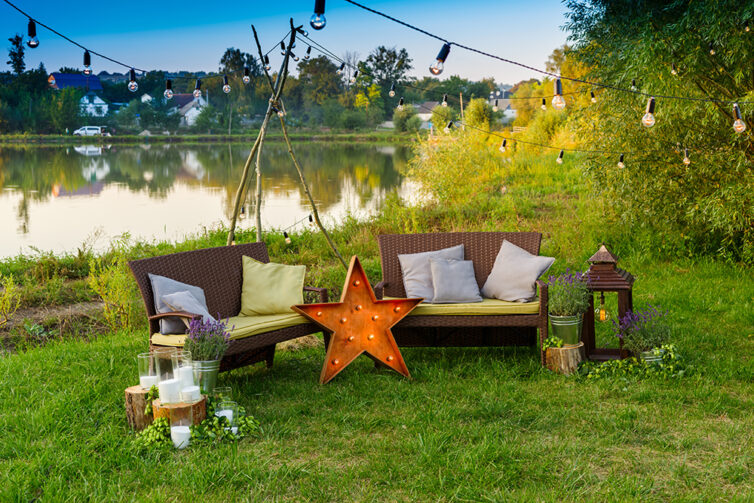 Garden party with cushions on benches, star light and garden string lights