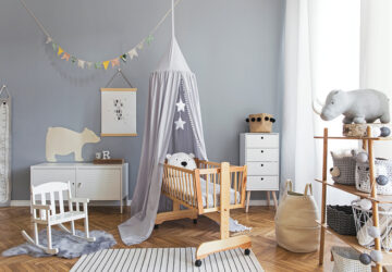 Scandinavian grey and white babies bedroom with small swinging cot