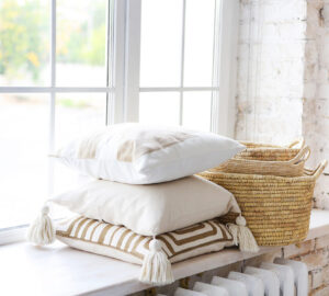 Accessories: pillows and baskets on window sill in white painted room