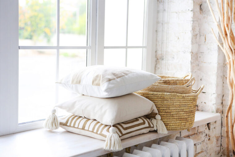 Accessories: pillows and baskets on window sill in white painted room