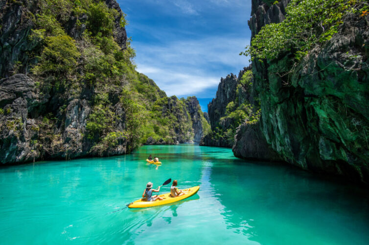 Family on holiday in philippines exploring in kayaks 