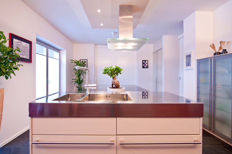 Metal/ stainless steel island woktop and sink in modern white kitchen