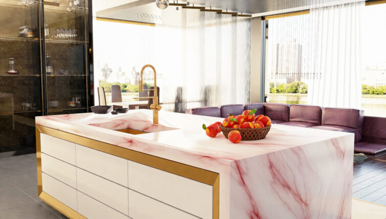 Modern designer kitchen with pink marble island counter top, with metal/brass draw triming and brass taps