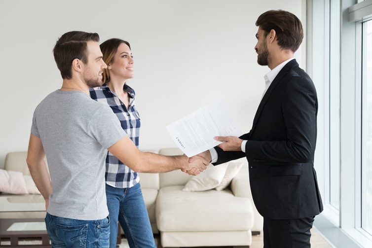 Realtor or landlord handshaking couple tenants make real estate deal