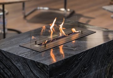 Beautiful marble black floor fireplace. Minimalism interior, alternative bio fireplot fireplace on ethanol gas