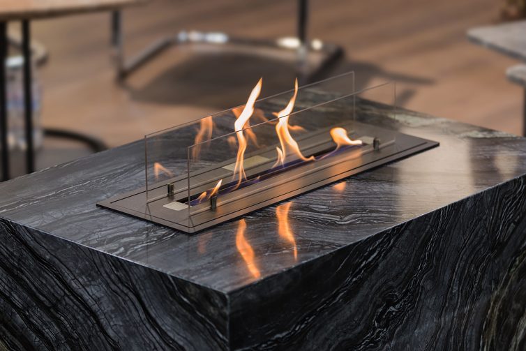 Beautiful marble black floor fireplace. Minimalism interior, alternative bio fireplot fireplace on ethanol gas