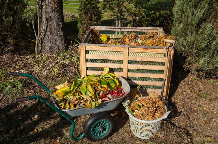 Wooden garden compost heap/container. With wheelbarrow and backet of garden waste