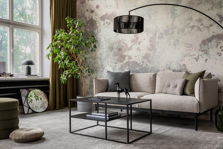 Industrial and loft living room interior with concrete walls, beige sofa, and large overhanging lamp