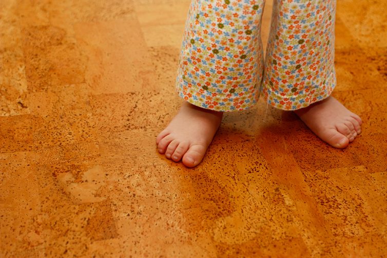 Young childs feet on cork tiled floor