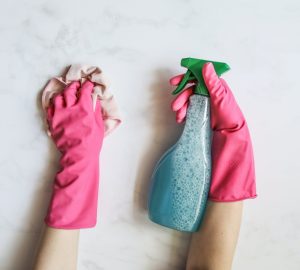 Pink rubber gloves, cleaning cloth and spray