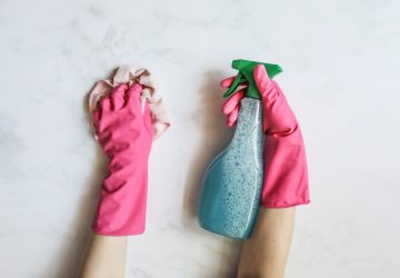 Pink rubber gloves, cleaning cloth and spray