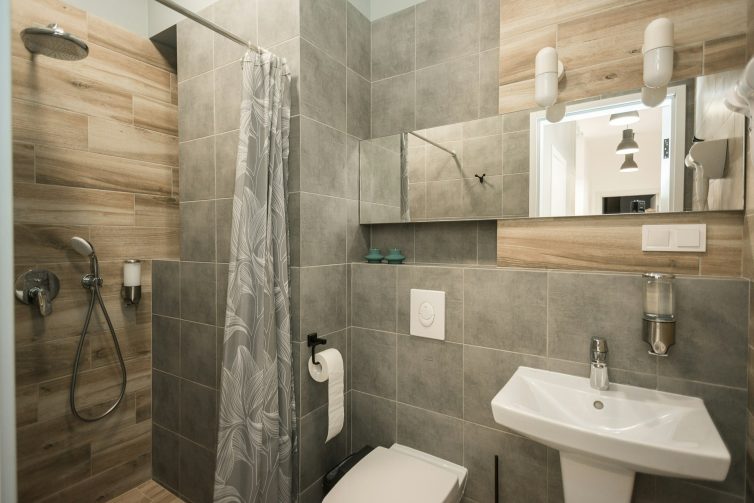 Bathroom With Grey Tiles And Faux Wood PVC Wall Panels