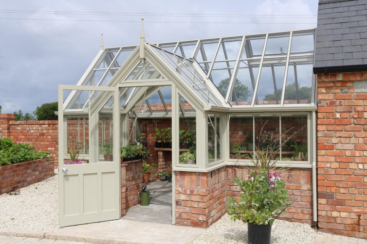 Garage with attached brick and wooden greenhouse
